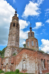 Fototapeta premium part of a ruined church with a bell tower overgrown with grass against the background of a cloudy sky, close-up