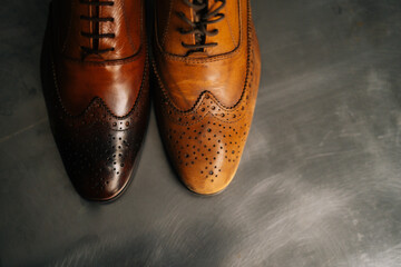 Close-up top view of old light brown leather shoe and repaired shiny shoes after restoration working. Concept of cobbler artisan repairing and restoration work in shoe repair shop.