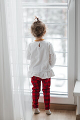 Fototapeta na wymiar little child looking out window, quarantine at home, self isolation, stay at home