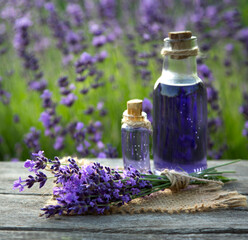 Obraz na płótnie Canvas Essential oil bottle and lavender flowers field
