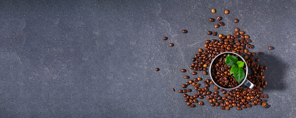 Roasted brown coffee beans on a gray background. Template for advertising coffee. Top view. Banner.
