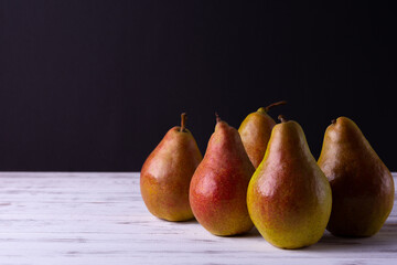 Ripe pears on a wooden table are collected in a group