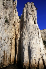 Close-up view of the steep rock walls of the creek with climbers in action, Parc National des Calanques, Marseille, France