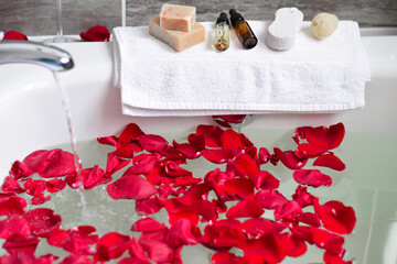 Bathtub with red rose petals filling up with water