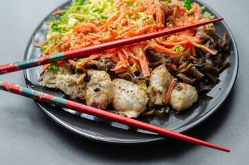 Cooked chicken breast pieces with egg noodles, carrots, and cabbage in a savory chow mein sauce