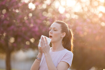 Woman sneezing because of spring pollen allergy