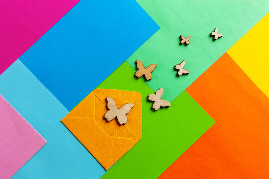 Close up photo of batterflies silhouettes on varicoloured colorful paper background. Top view, spring and various holidays and events concept