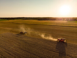 Fototapeta premium Aerial view of agricultural parcels of different crops. Hay bale fields and farmlands of Lithuania. Harvesting machinery or equipment.