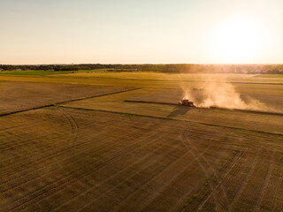 Aerial view of agricultural parcels of different crops. Hay bale fields and farmlands of Lithuania. Harvesting machinery or equipment.