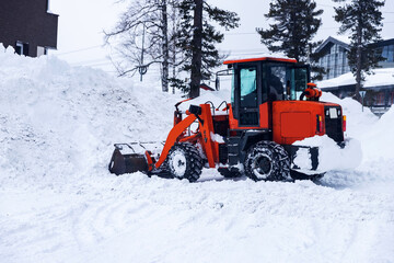 Fototapeta na wymiar Snow removal excavator tractor cleaning on winter road covered with snow