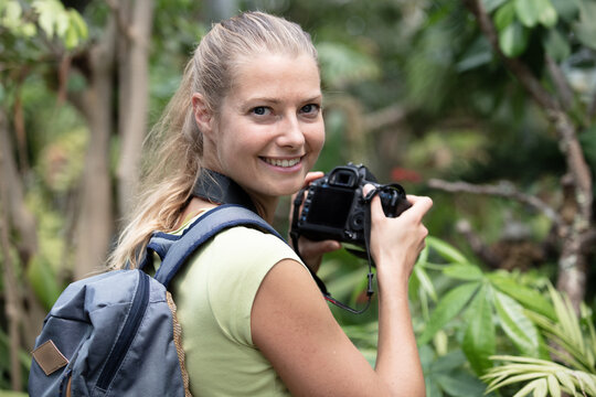 professional woman photographer taking camera outdoors