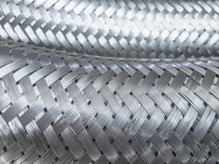 Long metal flexible compensator pipes metal texture closeup. Selective focus. White metal industrial construction.