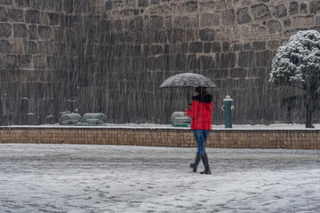 People walk on stret under snowfall