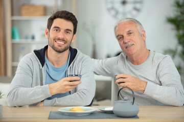 son and father taking tea at home