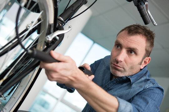 concentrated man pumping up the tires on his bicycle