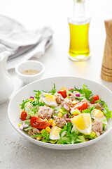 Tuna salad with boiled egg, tomato, lettuce, corn and red onion. Healthy and detox food concept. Ketogenic diet. Fresh vegetable salad bowl on white background