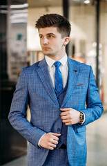 Handsome young guy model posing in blue suit