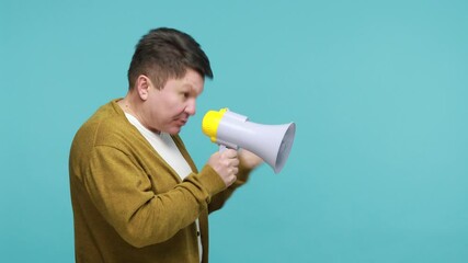 Profile portrait concentrated mature man leader in white t-shirt and cardigan talking at megaphone, expressing his point of view, making announcement. Indoor studio shot isolated on blue background - Powered by Adobe