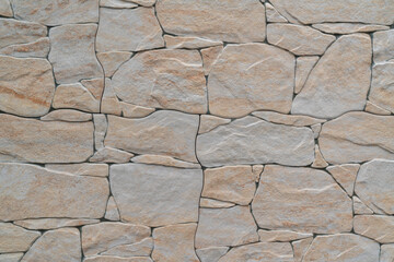 Background of a wall made with different-sized gray and orange stones