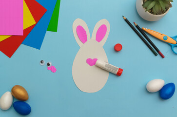 Happy Easter day.Holiday greeting card with your own hands step by step.Leisure for children.A congratulatory gift.Cute white Easter bunnyon a blue background.Instruction. DIY. step 7