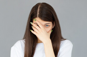 Young woman with hand on her face isolated on gray background, facepalm