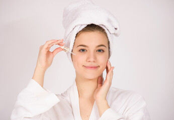 woman portrait close up holding pipette oil  serum over her face, skin care concept