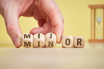 The concept mijor and minor on wooden cubes is turned over by hand.