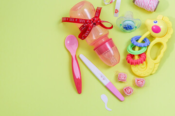 Pregnancy test and accessories.

Pregnancy test and baby accessories lie on the right on a yellow pastel background with space for text on the left, top view, close-up.