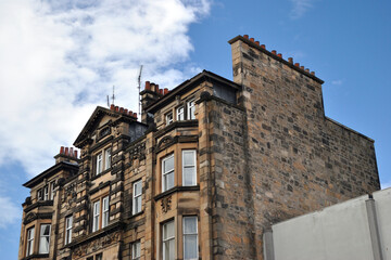 Fototapeta na wymiar 19th Century Stone Tenement Building seen from Below against Blue Sky