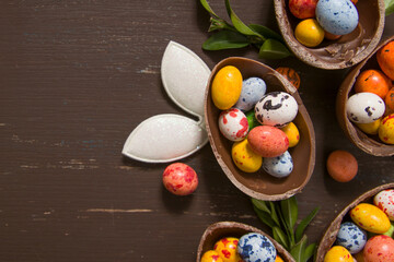 Easter eggs hunt concept with chocolate eggs and bunny on wooden background