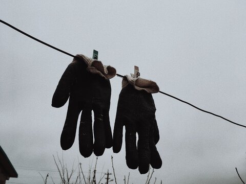 Low Angle View Of Gloves Hanging On Clothesline Against Clear Sky
