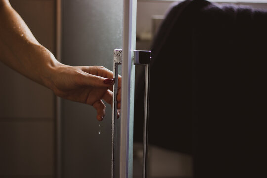 Cropped Image Of Woman Holding Bathroom Door After Shower