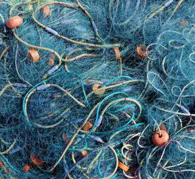 Blue nylon fishing net with orange foam floats and lead sinkers.