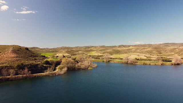Drone aerial view in Spain above the blue lake flying forward