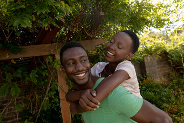 African american couple on sunny garden terrace a man carrying her smiling