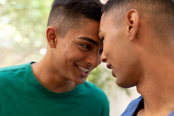 Fototapeta premium Diverse gay male couple looking at each other and smiling