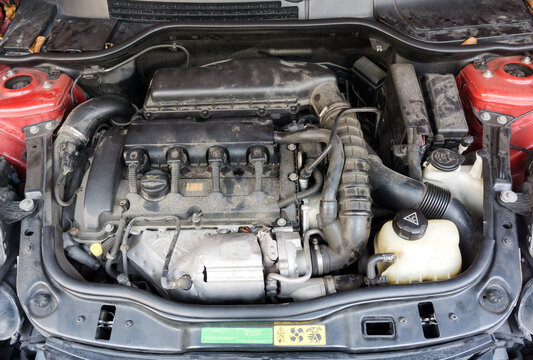 Image of dirty engine compartment of car with Device of engine on background.