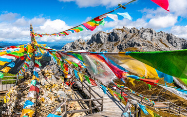 Shika mountain summit view in middle of many colorful Tibetan Buddhist prayer flags and blue sky Shangri-La Yunnan China