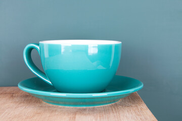 Green coffee cup in front of blackboard