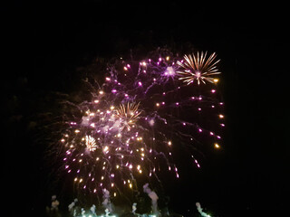 fireworks on a night in a harbor, taken in the middle of the crowd