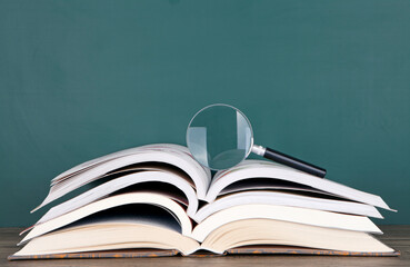 A stack of books and a magnifying glass on it