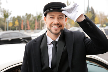 Portrait of handsome chauffeur near car outdoors