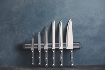 Magnetic holder with set of knives on color background