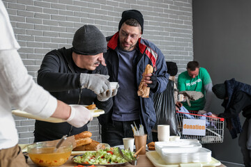 Volunteer giving food to homeless people in warming center