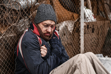 Poor homeless man outdoors on winter day