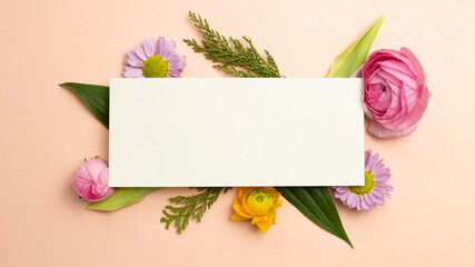 Blank memo pad with flowers on pink background. flat lay, top view, copy space