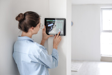 Woman using smart home security system control panel