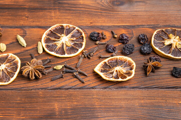 Spices, cloves, anise, orange lie on a wooden table
