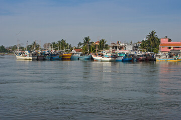 Fototapeta na wymiar Colorful fishing boats crowd the shores of Negombo Lagoon in Sri Lanka.