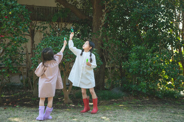 Fototapeta premium シャボン玉で遊ぶ姉妹